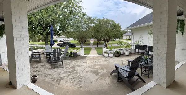 Wide view of the front courtyard and seating area before pressure washing